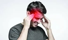 তীব্র মাথা ব্যথায় আক্রান্ত একজন ব্যক্তি দুই হাতে মাথা চেপে ধরে আছেন।