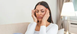 মাথা ঘোরা বা তীব্র মাথা ব্যথার যন্ত্রণায় কাতর একজন মহিলা
