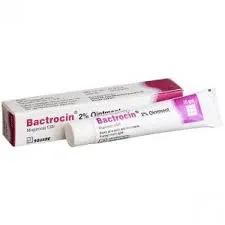 A white cardboard box and a matching tube of Bactrocin 2% ointment, a topical antibiotic containing Mupirocin USP, featuring pink and purple accents.