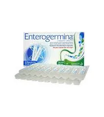 A white box of Enterogermina probiotics featuring blue and green graphics, displayed behind two rows of clear plastic liquid vials.