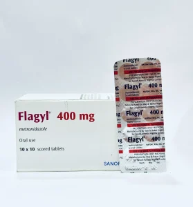 A white box and a silver blister pack of Flagyl 400 mg tablets. The packaging clearly displays the brand name "Flagyl" and the generic name "metronidazole" for oral use.