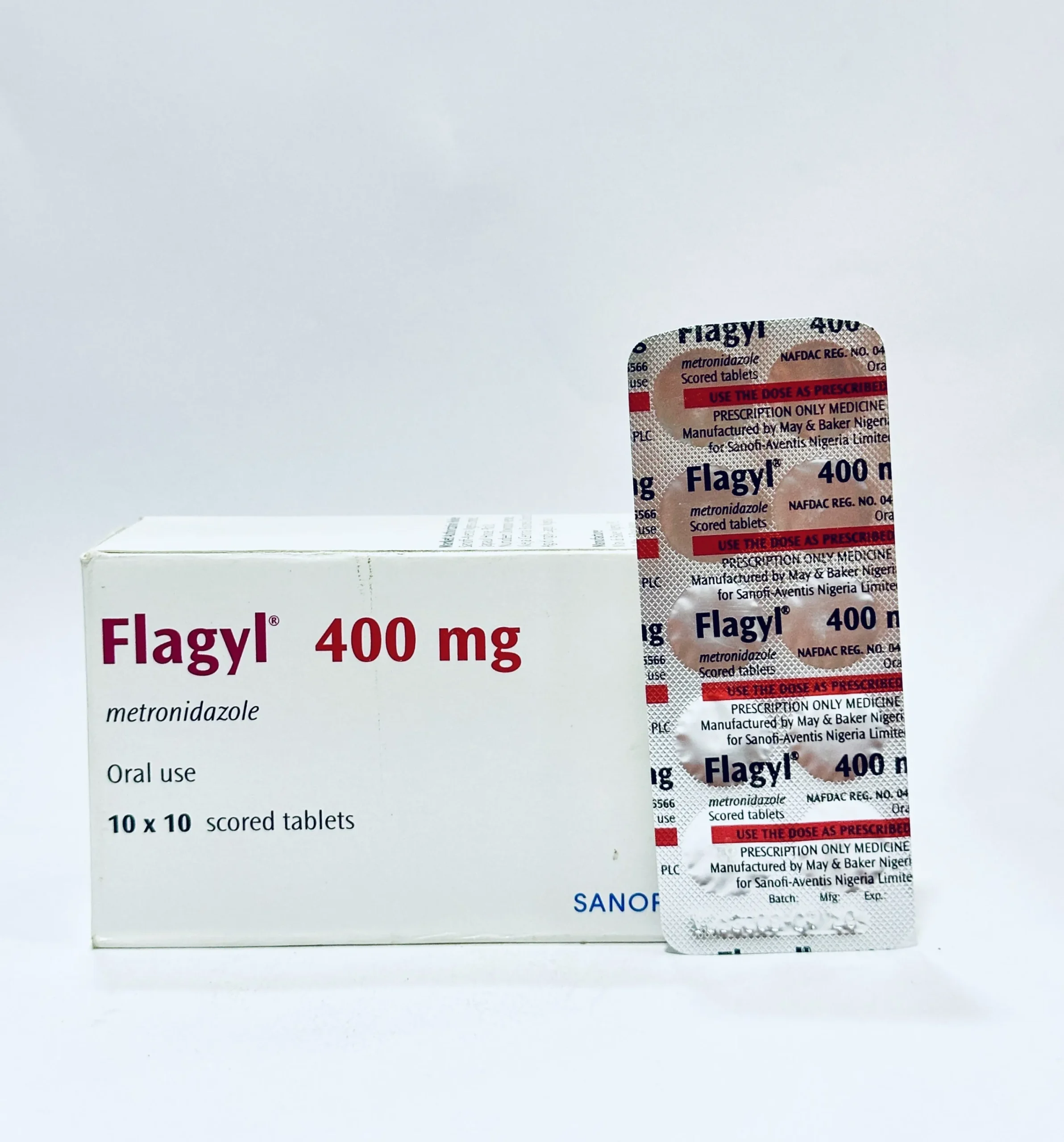 A white box and a silver blister pack of Flagyl 400 mg tablets. The packaging clearly displays the brand name "Flagyl" and the generic name "metronidazole" for oral use.