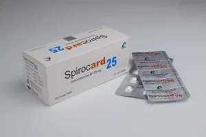 A white rectangular box and two silver foil blister packs of Spirocard 25, which are 25 mg Spironolactone film-coated tablets.