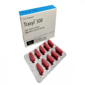 A white box for Traxyl 500 medicine sitting next to a silver blister pack containing ten red capsules. The packaging identifies the contents as Tranexamic Acid BP 500 mg, manufactured by Nuvista Pharma Limited.