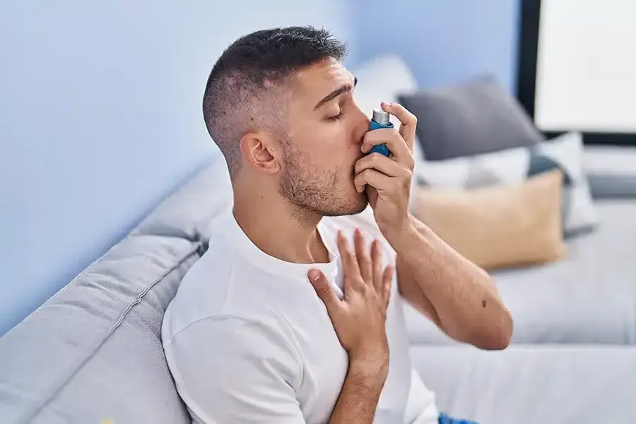 Man using inhaler for shortness of breath