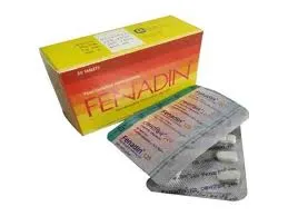 A yellow and orange box of Fenadin antihistamine medication alongside two silver blister packs of fexofenadine hydrochloride tablets.