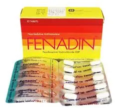 A yellow and orange box of Fenadin non-sedative antihistamine pills displayed with a silver blister pack containing white tablets.
